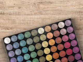 eye shadow palette on wooden background