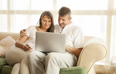 Fototapeta premium middle aged couple with a computer