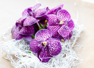 Obraz na płótnie Canvas bouquet of purple orchids on craft paper close up