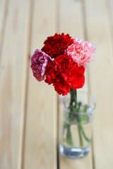 Red and pink of carnation flowers on wood