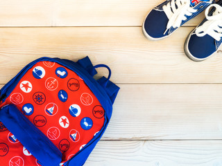 Children's backpack on the wooden board. Nautical theme. View from above
