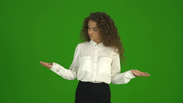 The businesswoman try to make a choice and stand on the green background