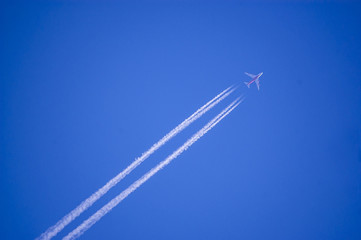 Plane flying on a perfectly blue sky with vapor trail