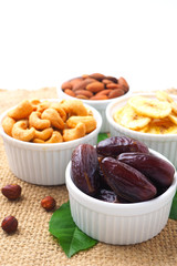 Close up of date fruits and nuts on a sackcloth background.