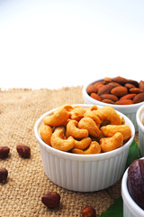 Close up of cashew nuts, dried fruits and nuts on a sackcloth background.