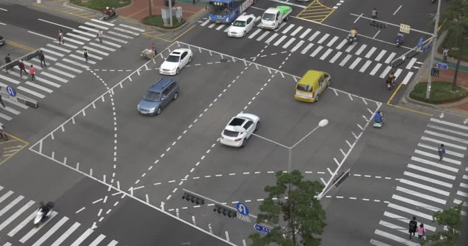 In city Seoul, South Korea at the big crossroads passing cars, buses, motorcyclists and people crossing road