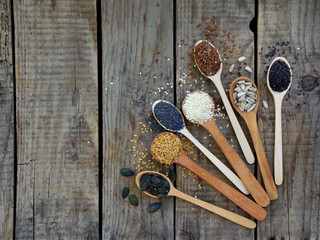 flax, black, white sesame seeds, sunflower and poppy in a wooden spoon. selective focus