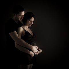 Portrait of sensual couple - caucasian pregnant women with her man - low key