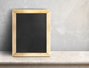 Blank blackboard on beige marble table at grey concrete wall,Tem