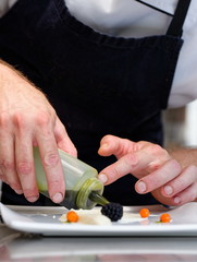 Male chef garnishing his dish, ready to serve