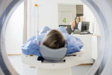 Doctor's Looking At Patient Undergoing CT Scan