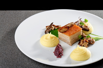 Plated freshly grilled pork belly with potato and mushrooms/fine dining