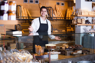 Smiling man selling tarts and sweet pastry