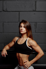 Fototapeta na wymiar Muscular body of a young woman, abs close up. Woman's abs