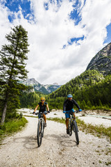 Obraz premium Couple on mountain bikes in the Italian Dolomites.