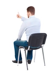 back view of young business man sitting on chair and thumbs up. man watching. Bearded businessman...