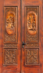 Fototapeta na wymiar carved wooden door with Biblical figures in the old church in Eu