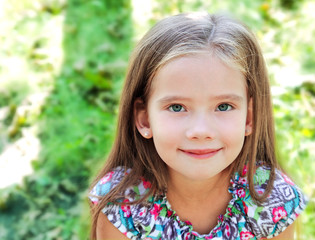 Portrait of adorable smiling little girl in summer day