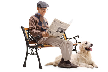 Senior man reading a newspaper with his dog