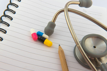 Colorful  capsule drug on white  book background