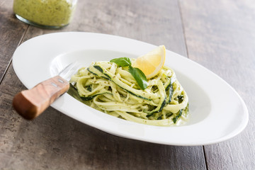 Zucchini noodles with pesto sauce on wooden table

