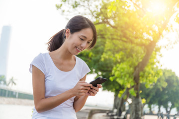 Woman using cellphone in the park