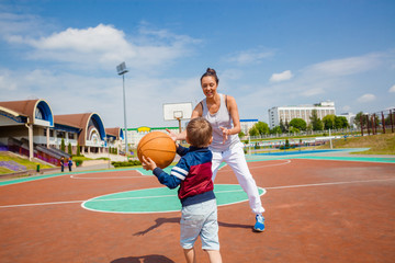 Obraz premium Mom and little boy son playing basketball