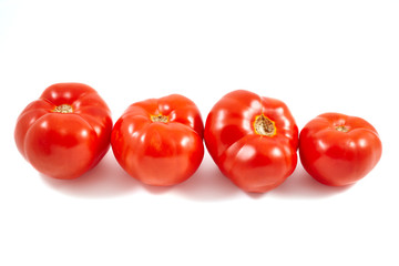 A tomato. Red tomato on a white background. Harvest vegetables. Autumn harvest. Red, juicy, ripe tomato.