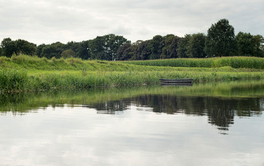 Dutch river de Berkel with small boat corn field. Achterhoek. Ge