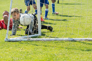 Boys playing football soccer game on sports field