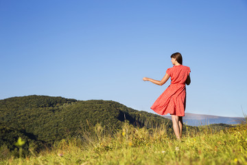 Beautiful young girl walking on mountain top.