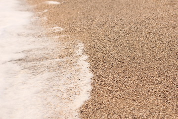 Wave on the pebbles beach. close up
