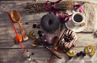 fresh donut with coffee on wooden table with napkin, spoon and f