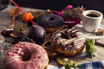 fresh donut with coffee on wooden table with napkin, spoon and f