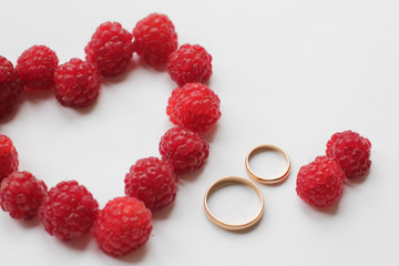 wedding card with a heart of raspberry and golden rings