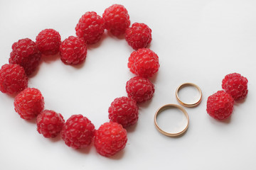 wedding card with a heart of raspberry and golden rings