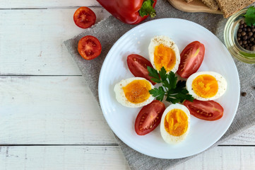 Boiled egg and fresh tomato, black bread - light diet breakfast. The top view