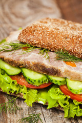 Tasty rye bread sandwiches with roast meat and vegetables