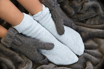 Feet in comfortable and warm woolen socks on a blanket