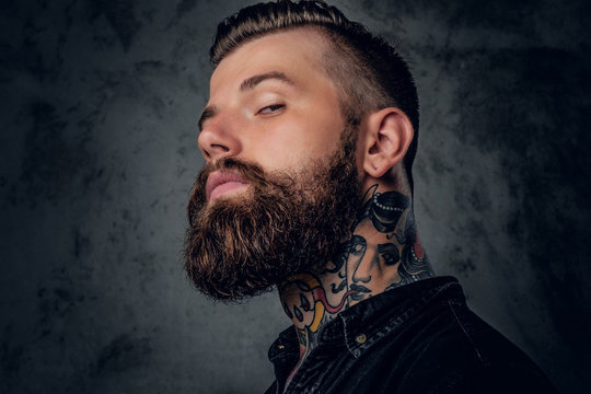 Bearded male in black shirt with tattoo on his neck.