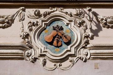 Fototapeta na wymiar Sculpture of the three violins, attached to the old house of Prague