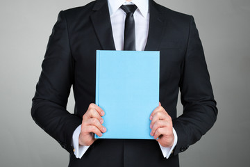 Unrecognizable businessman holding a book closeup