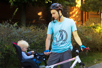 Naklejka premium Father and son traveling on bicycle, child is sitting in a bike