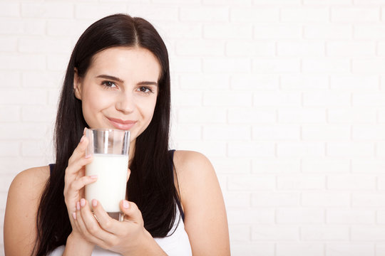 Happy young woman drinking milk