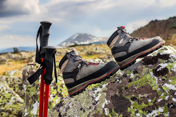 boots and trekking poles on the stone