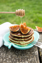 making pancakes with figs and honey in the garden on a rustic ta