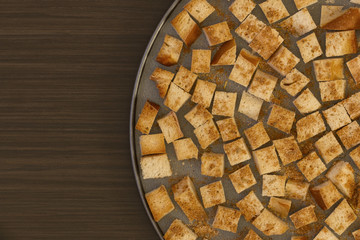 Croutons on a baking sheet on a dark background