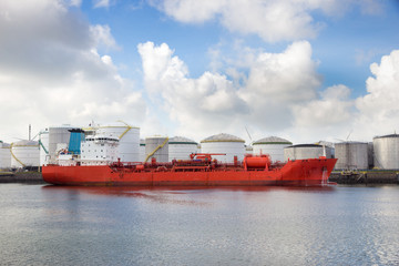 Oil tanker moored near oil silo's