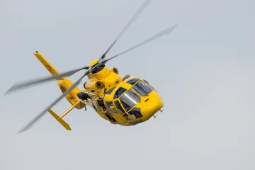 Afwasbaar Fotobehang Helikopter Reddingshelikopter vliegt snel