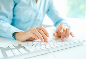 Woman office worker typing on the keyboard